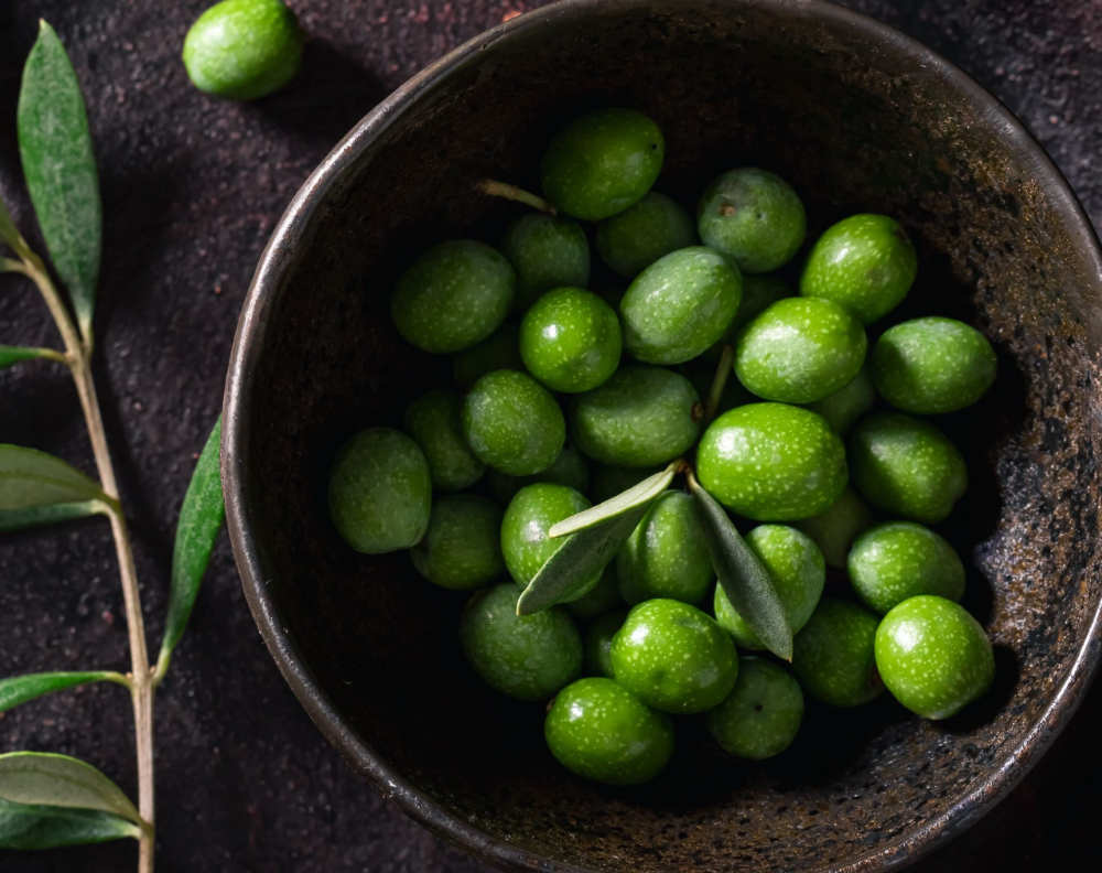 Primer plano de aceitunas verdes utilizadas en la elaboración del aceite TuAceite de siempre