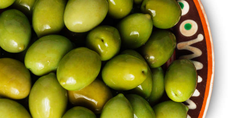 Patrón repetitivo de aceitunas verdes sobre fondo blanco para diseño gráfico